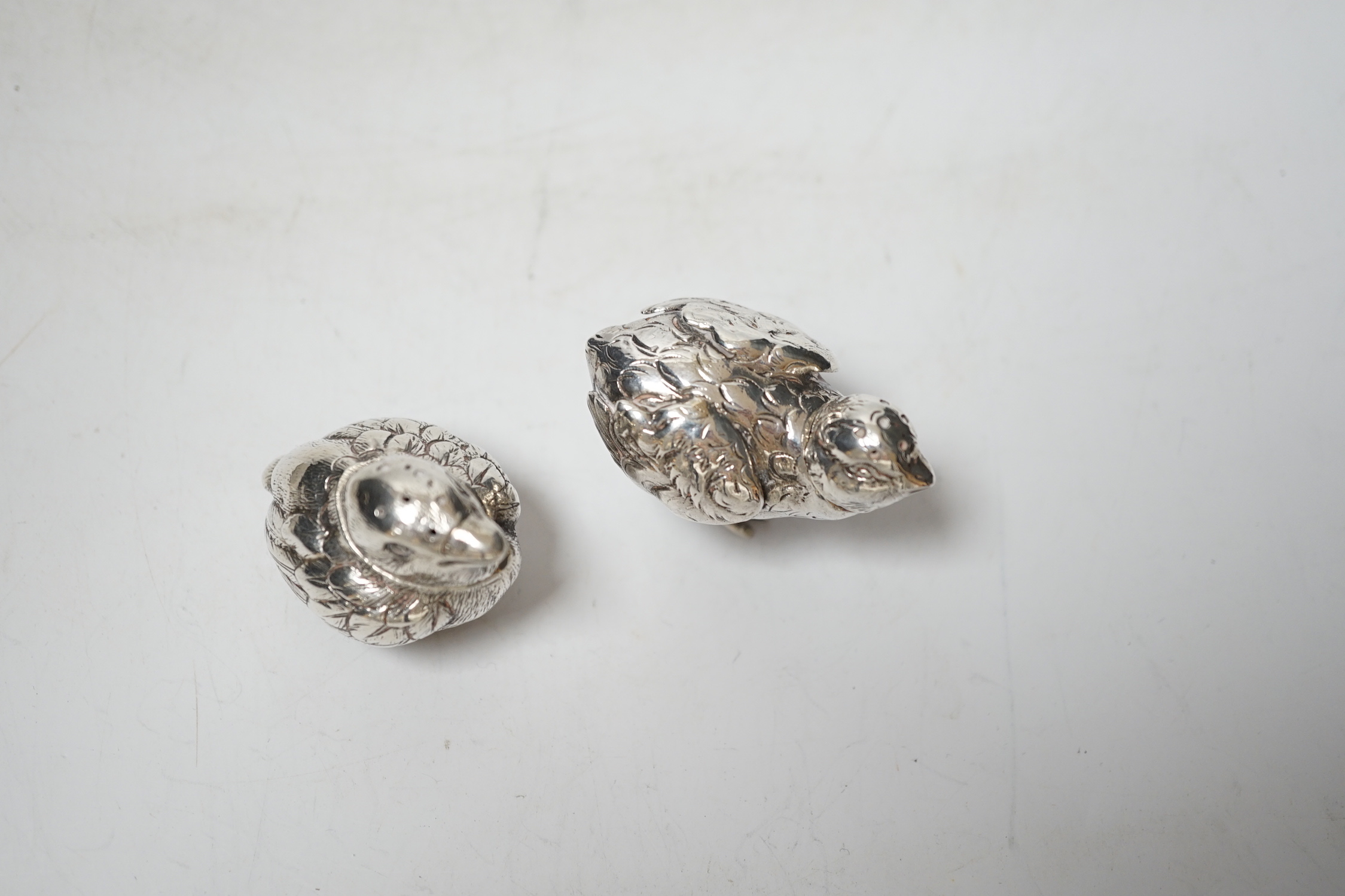 Two novelty silver pepperettes, modelled as chicks, the smallest with import marks for London, 1925, the other with import marks, but no date letter.